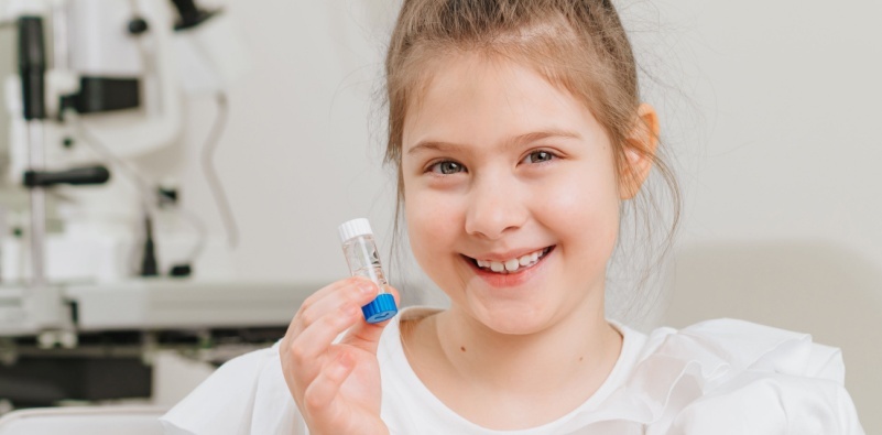 kid holding contact lenses